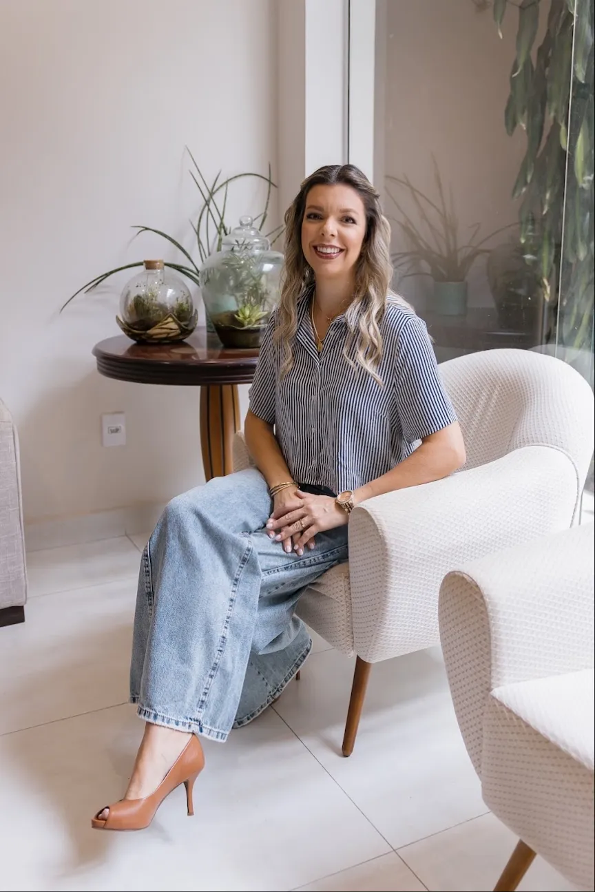 Dra. Giovanna Gastaldi sorrindo, sentada numa poltrona do consultório